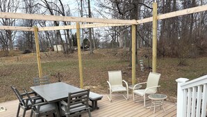 A wooden deck with a table and chairs, surrounded by a white railing. - Tranquil 3-bedroom house with AC in charming Bloomington (Bloomington)