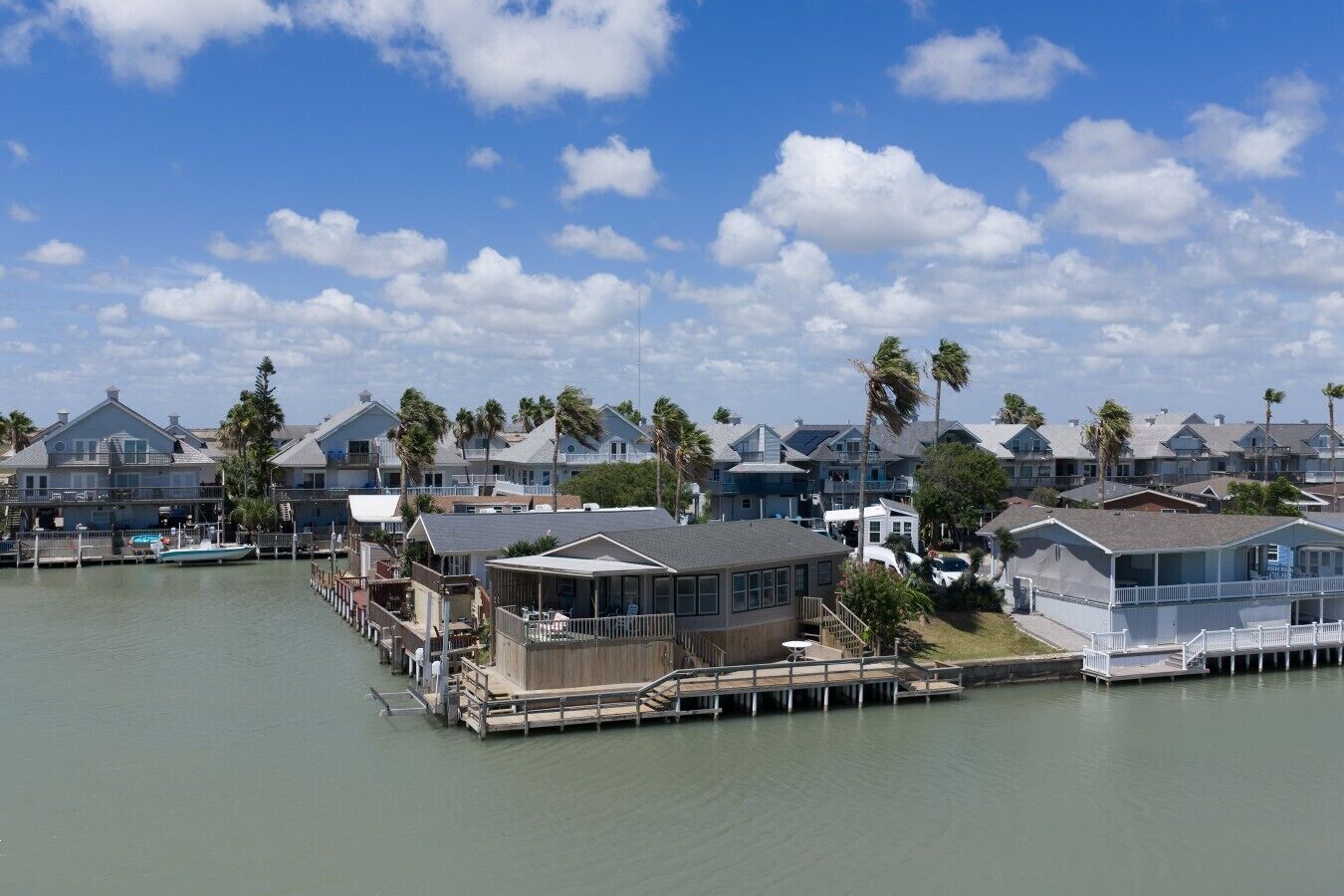 A waterfront property with multiple houses, docks, and a clear sky.