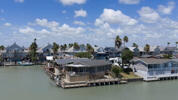 A waterfront property with multiple houses, docks, and a clear sky.