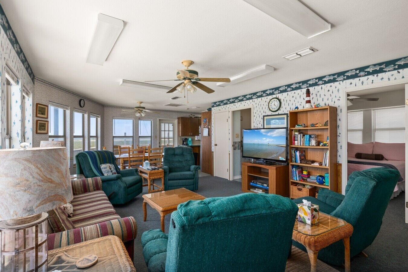 A cozy living room with a television, bookshelves, and comfortable seating.