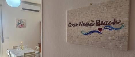 Un comedor con una mesa dispuesta para cuatro personas, sillas y una lámpara colgante.