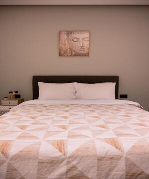 A bed with a geometric patterned bedspread, a dark headboard, and a wall-mounted artwork above it. - Light & Kozy Apartment - Central Patra Luxury Stay (Patra)