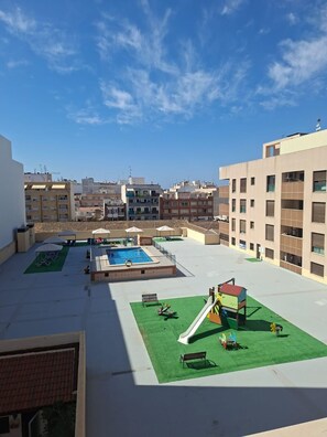 Un toit-terrasse équipé d’une piscine, d’un espace de jeux pour enfants et d’un toboggan.