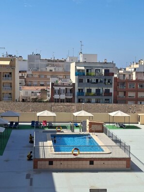 Piscina no terraço com vista para os edifícios ao redor.