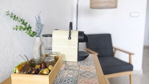 A kitchen area with a wooden table, a coffee machine, a chair, and a vase with plants. - Peaceful 2-Bedroom Apartment, Shared Pool, Balcony, Torrevieja, Alicante (Torrevieja)
