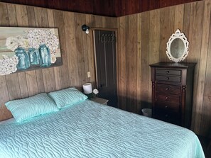 A bedroom with a bed, a dresser, a mirror, and a wall-mounted light fixture. - 3 bedroom Beach House central to food and shops, steps away from the ocean. (Old Lyme)