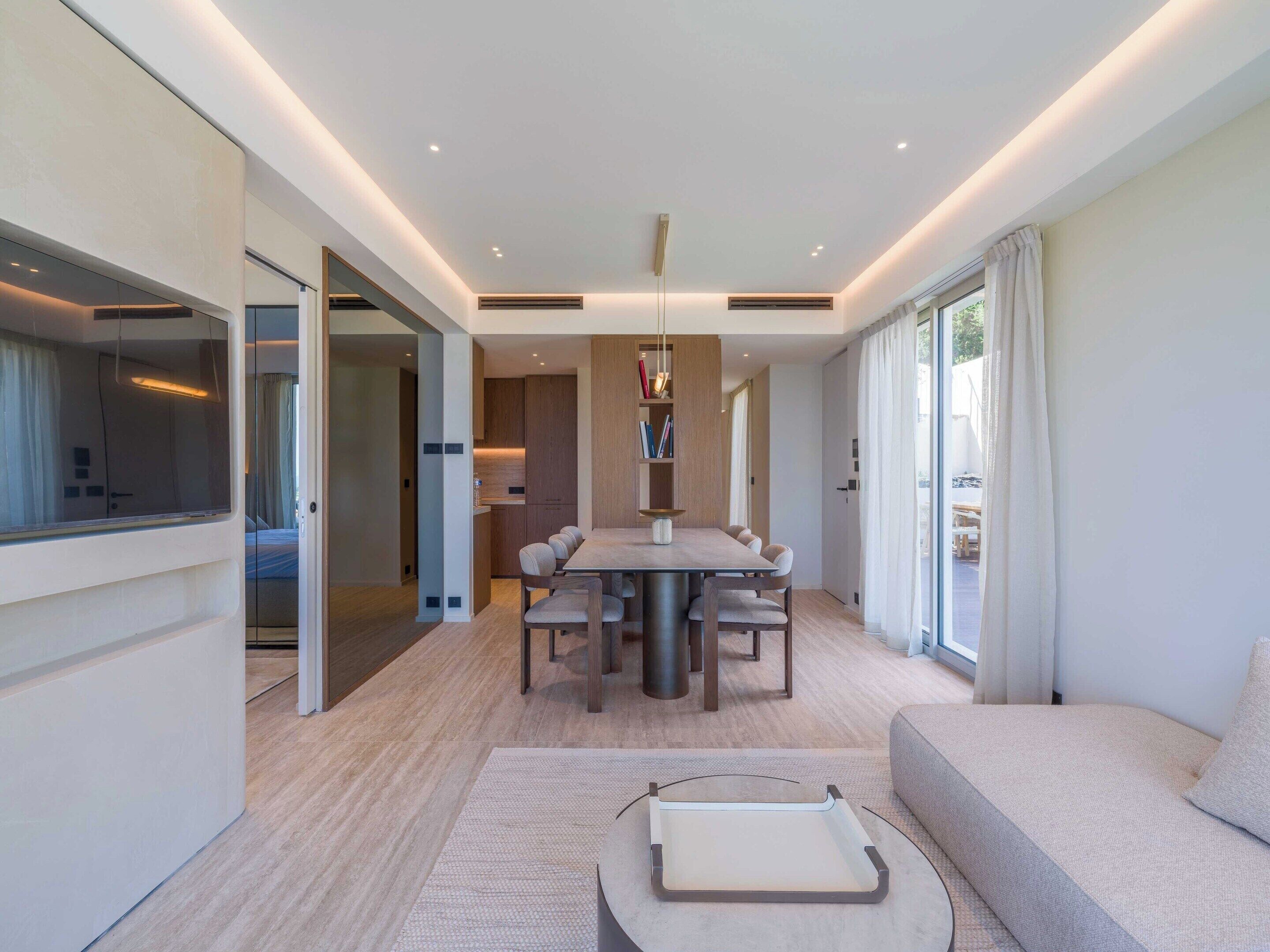 Un intérieur moderne comprenant un coin repas, un canapé et une vue sur l’extérieur.
