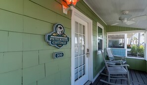 Une véranda avec des fauteuils à bascule, une enseigne indiquant «
Peterson Cottage
» et le numéro «
109
» sur le mur.