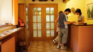 Ein Empfangsbereich mit Holztresen, einer Glastür und einem Fliesenboden.