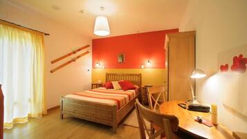 A bedroom with a bed, bedside table, lamp, and a chair.