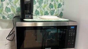 Un four à micro-ondes doté d’un écran numérique et d’un panneau de commande, posé sur un plan de travail de cuisine.