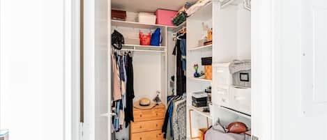 Un dressing avec des étagères, des tiroirs et une tringle pour suspendre les vêtements.