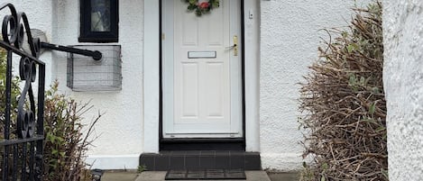 A white building with a black door, number 43, and a wreath on the door.
