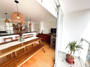 Una cocina moderna con comedor, banco de madera y plantas en macetas.