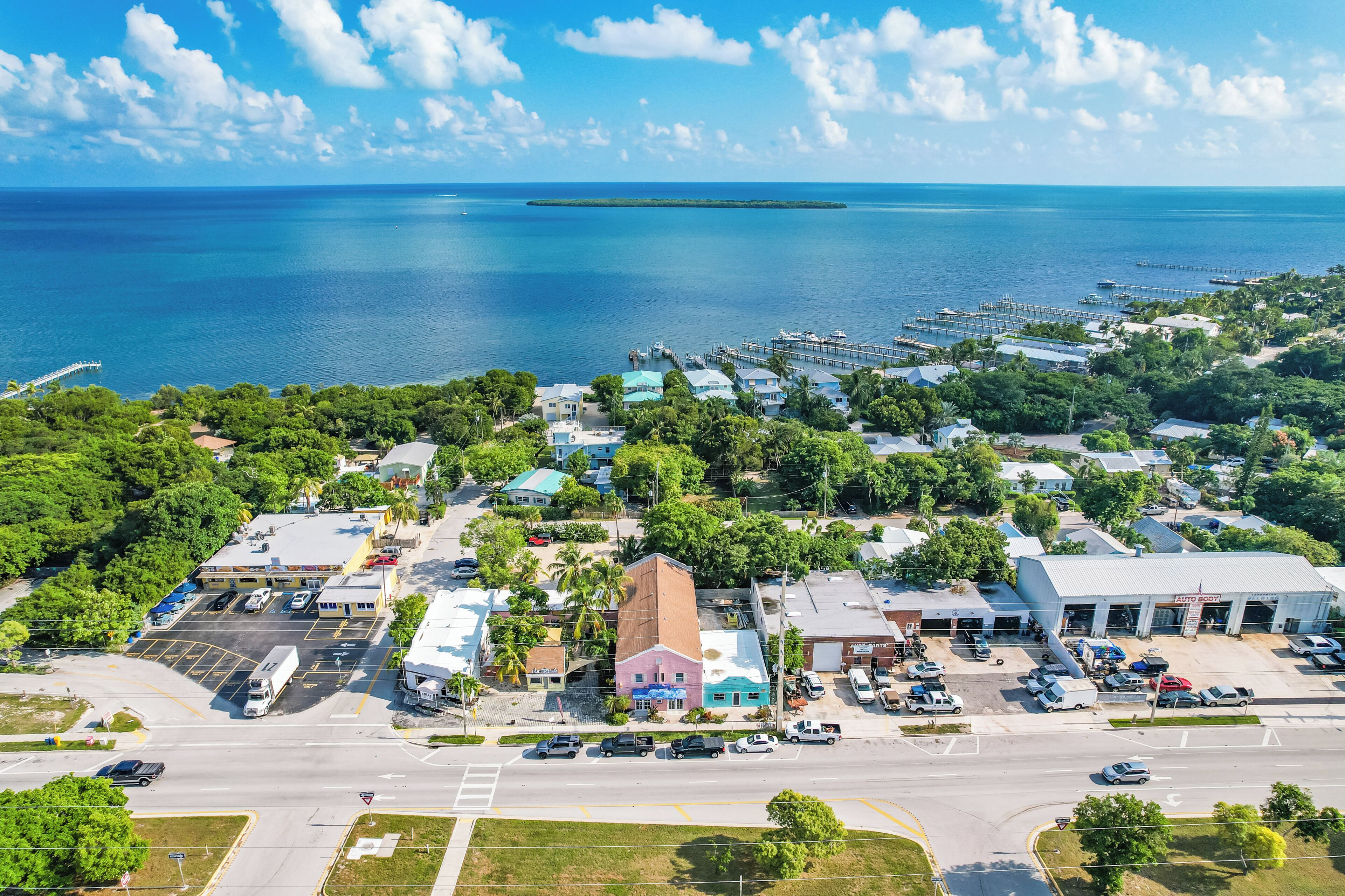 An aerial view of a coastal town with a marina, roads, and buildings.