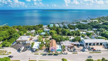 An aerial view of a coastal town with a marina, roads, and buildings.