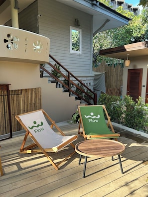 A wooden deck with two lounge chairs, one with a 'Flow' logo and another with a 'Flow' logo and a green cushion. - Flow Hua Hin - Ice Bath and Villa (Hua Hin)