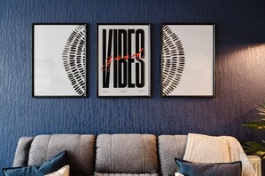 A wall with three framed artworks featuring the word 'VIBE' and a partial leaf design. - Etihad Co-op Live 3-bed Free Parking (Manchester)