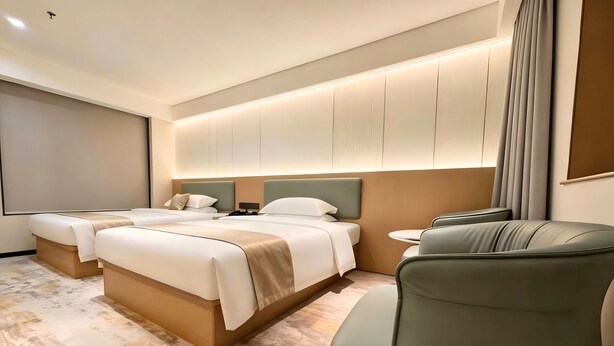 A hotel room with a large bed, a seating area with a sofa, and a flat-screen TV. - Wanlin Yijing Holiday Hotel (Foshan)