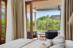 Ein Schlafzimmer mit großem Fenster, einem Bett und Blick auf Pool sowie Sitzgelegenheiten im Freien.