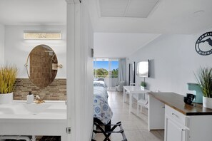 Une chambre d’hôtel moderne dotée d’une salle de bain, d’un coin repas et offrant une vue sur l’extérieur.