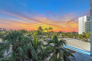 A view of a parking area with palm trees and a building in the background. - New Listing -Cozy Suite room w/blacony City-View at Ocean Manor Resort (Fort Lauderdale)