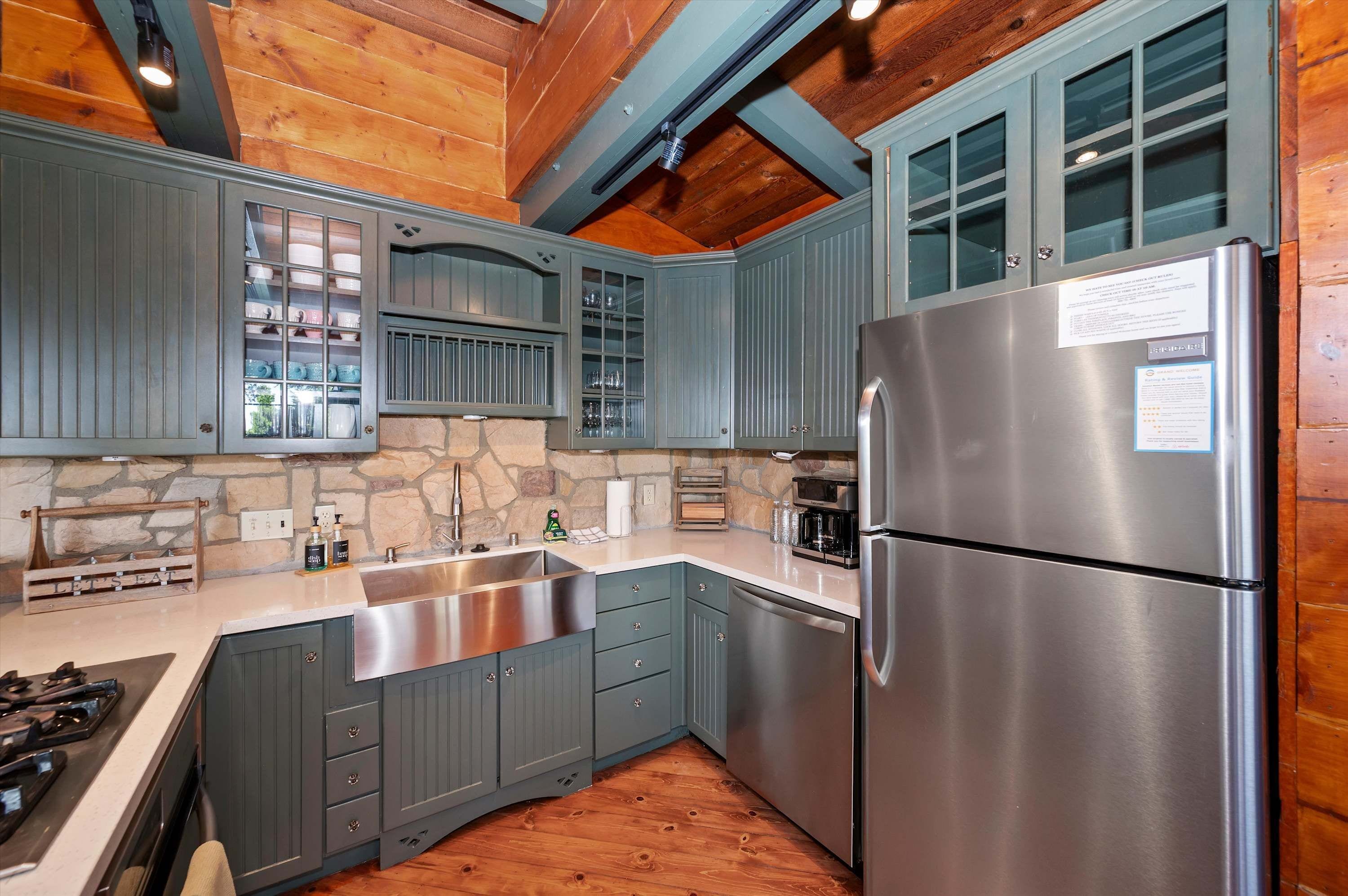 A kitchen with a stone backsplash, a stainless steel refrigerator, and wooden cabinets.