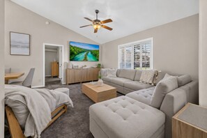 A modern living room with a sofa, a coffee table, and a TV.
