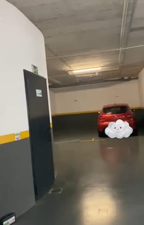 Eine Parkgarage, in der Ferne ein rotes Auto geparkt ist.