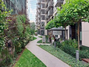 A pathway leading to a modern building with a restaurant named 'Frank B' and a well-maintained garden area. - Warsaw City Apartment With Balcony (Warsaw)
