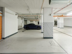 Eine Parkgarage mit einem blauen Auto in Parkplatz Nummer 103.