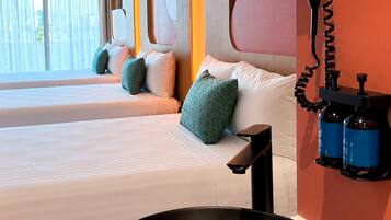 Habitación de hotel con una cama grande, una mesita de noche, un lavamanos negro y un secador de pelo montado en la pared.