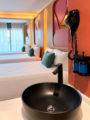 A hotel room with a large bed, a bedside table, a black sink, and a hairdryer mounted on the wall. - Hotel More  (Boca del Rio)