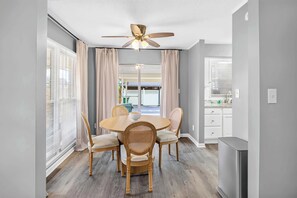A dining area with a round table and four chairs, a ceiling fan, and a view of the outside. - Dalraida 3BR Near Gunter Annex & Downtown (Montgomery)