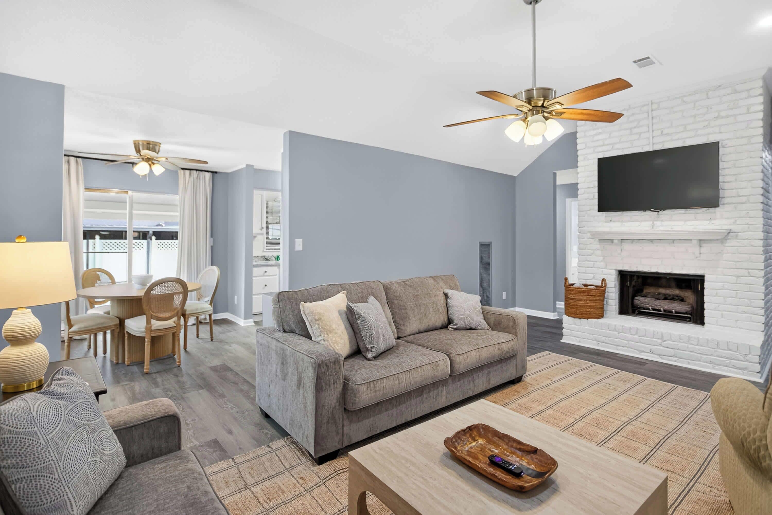 A modern living room with a grey sofa, a coffee table, and a fireplace.