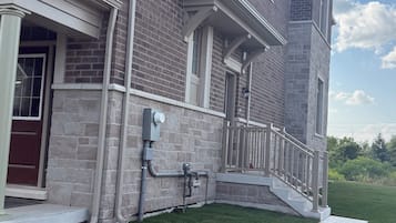 A two-story building with a brick facade, a covered porch, and a well-maintained lawn.