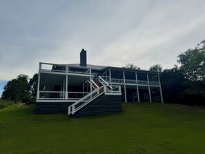Ein modernes Gebäude mit flachem Dach, großen Fenstern und einer Treppe, die zu einer oberen Ebene führt.