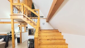 A wooden staircase leading to an upper level with a view of the living area below.