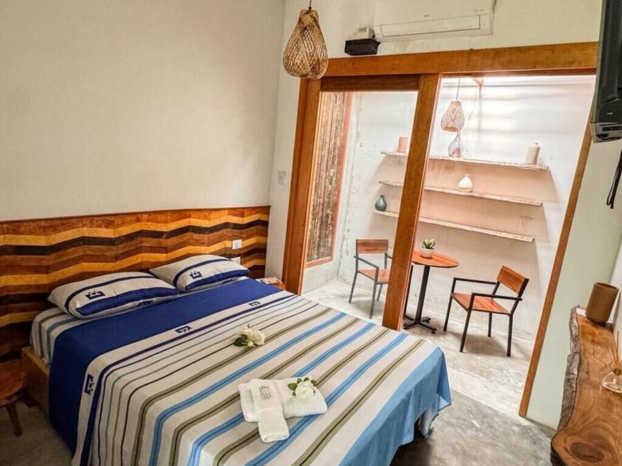 Habitación de hotel con una cama, una mesita y una silla.