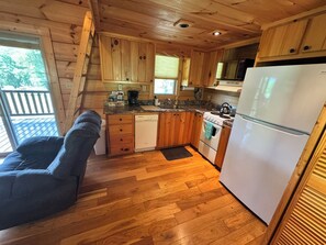 A compact kitchen with wooden cabinets, a refrigerator, a stove, and a sink. - Sunshine Cabin is ready to provide you with a peaceful stay! (Hot Springs)