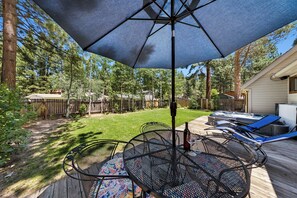 Eine Terrasse mit Tisch und Stühlen, einem Whirlpool und einem Holzboden.