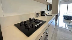 Une cuisine moderne avec un four noir, des armoires blanches et une grande fenêtre.