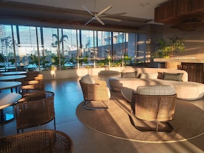 A modern lounge area with wicker furniture, a sofa, and a ceiling fan. - Luxury Apartment at Bello Horizonte Beach, Santa Marta (Santa Marta)