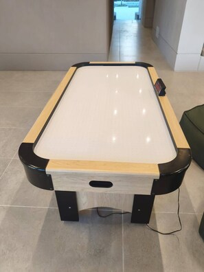 A pool table with a wooden finish and black legs, located in a hallway with tiled flooring. - Luxury Apartment at Bello Horizonte Beach, Santa Marta (Santa Marta)