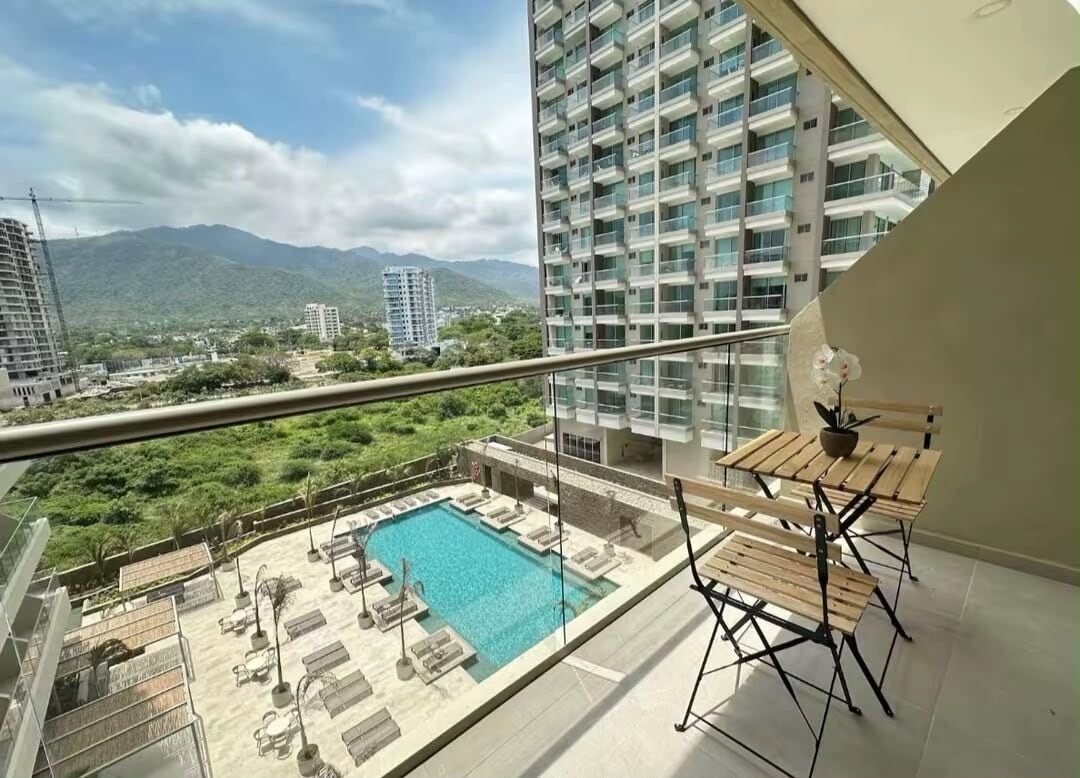 Ein Balkon mit Pool, Liegestühlen und einem Tisch.