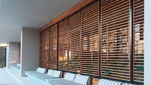 Un espace extérieur moderne, aménagé avec des bancs en gradins et des murs en bois à lattes.