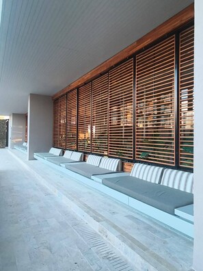 A modern outdoor seating area with tiered benches and wooden slatted walls. - Luxury Apartment at Bello Horizonte Beach, Santa Marta (Santa Marta)