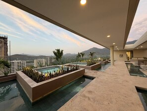 A rooftop pool area with multiple pools and a view of the cityscape and mountains. - Luxury Apartment at Bello Horizonte Beach, Santa Marta (Santa Marta)