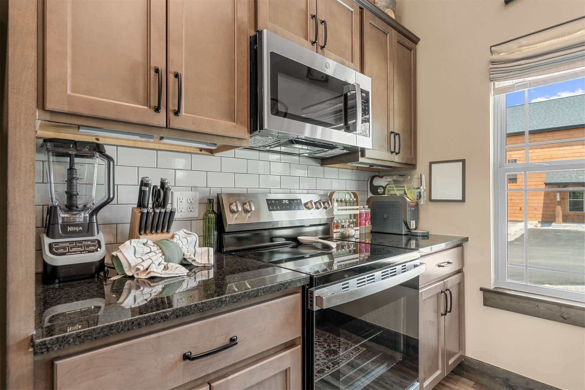 A kitchen with wooden cabinets, a microwave, a stove, and a dishwasher.
