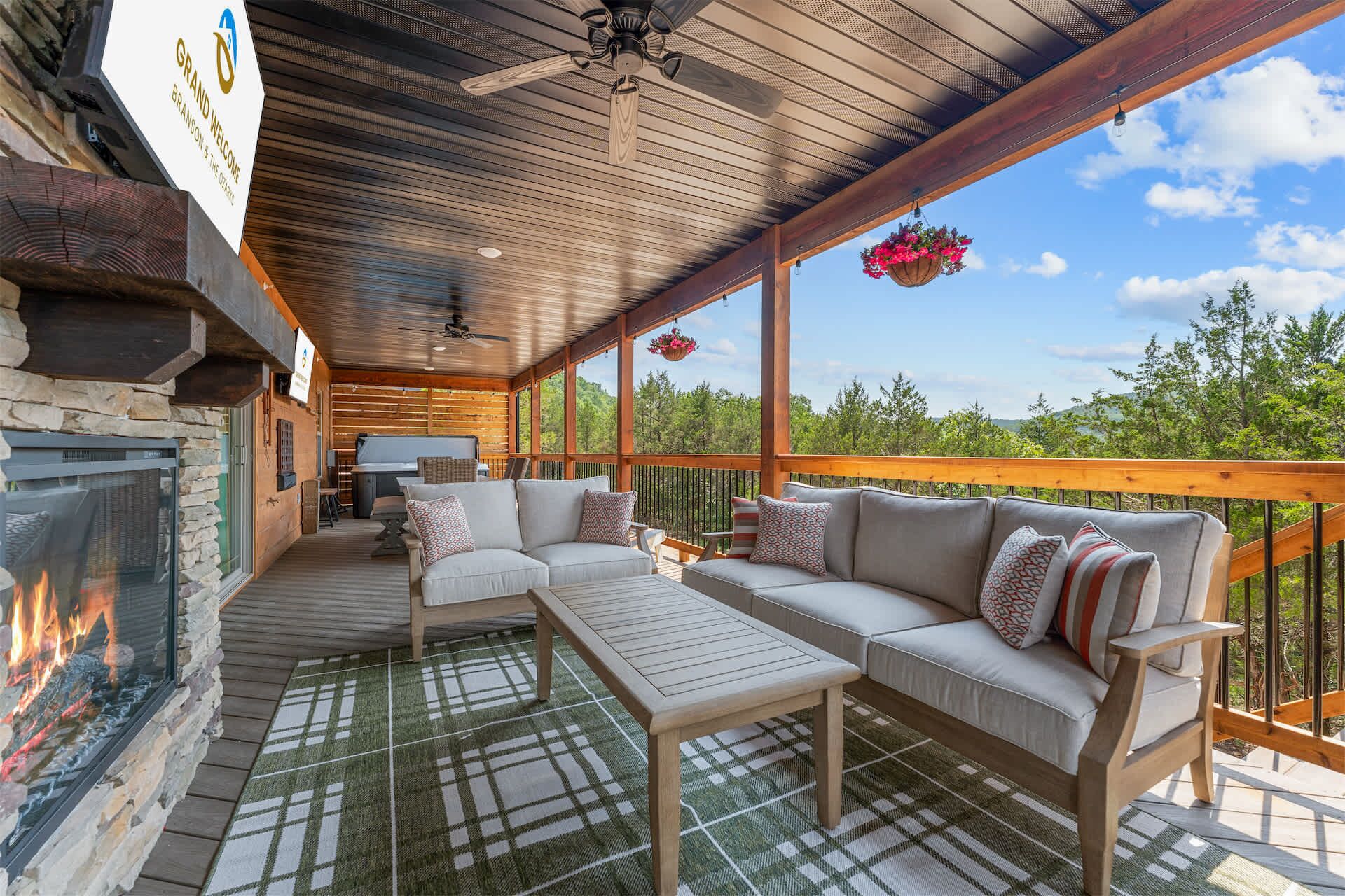 A covered outdoor seating area with a fireplace, a sofa, and a table.